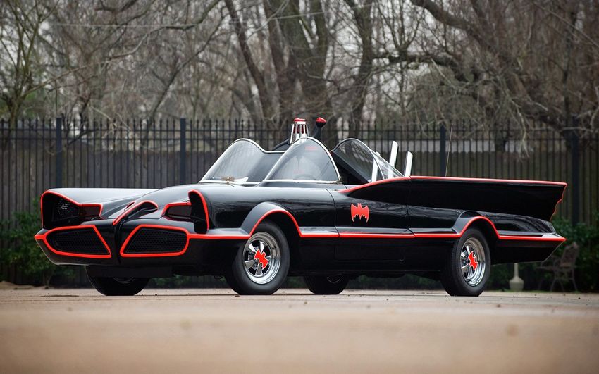 A clean and shiny black car with red elements and Batman sign on the left doors.