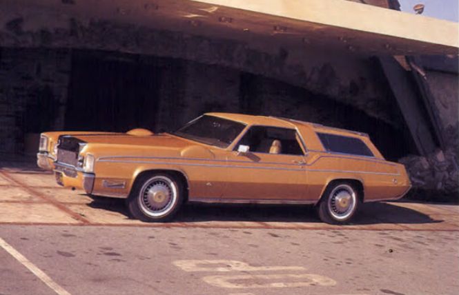 Dean Martin's modified orange car on a parking with a ruined building in the back.