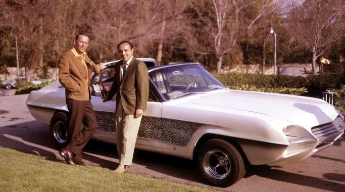 An old color photograph of Sinatra and Barris leaning on the Zebra Mustang in the sun.