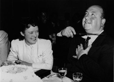 Hitch pretending to slash his own throat with a knife to the delight of his wife.