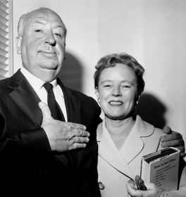 Hitch and Alma smiling, Alfred holding his hand on a hard as if he'd be swearing something.