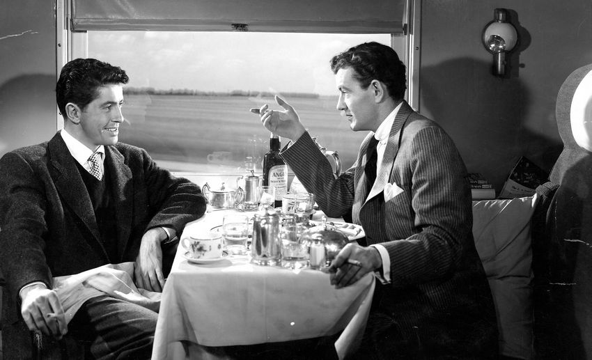 Bruno Antony and Guy Haines sitting in a train, enjoying a supposedly casual conversation.