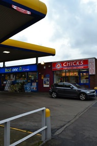 The plaque is hard to notice at first - it is on a petrol station's wall between two small shops.